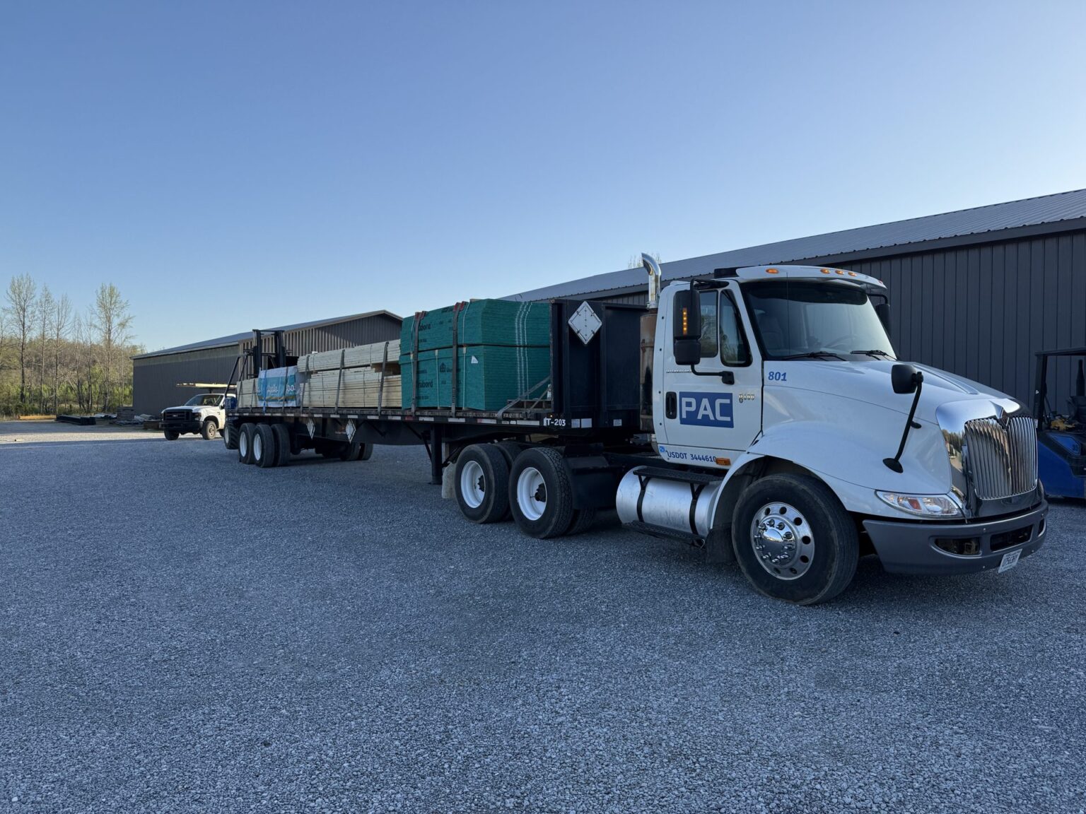 A PAC flatbed truck loaded with a wrapped material package at the Waverly lumber yard